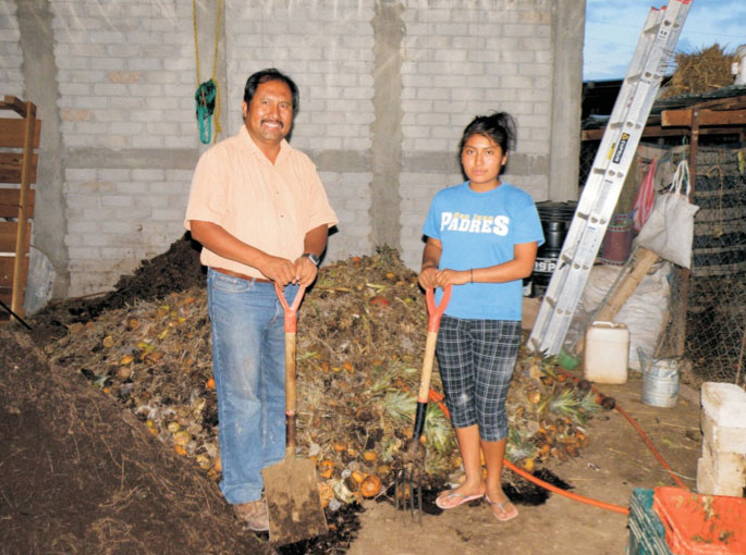 Jesús León Santos and his daughter Diana with the compost at their farm
